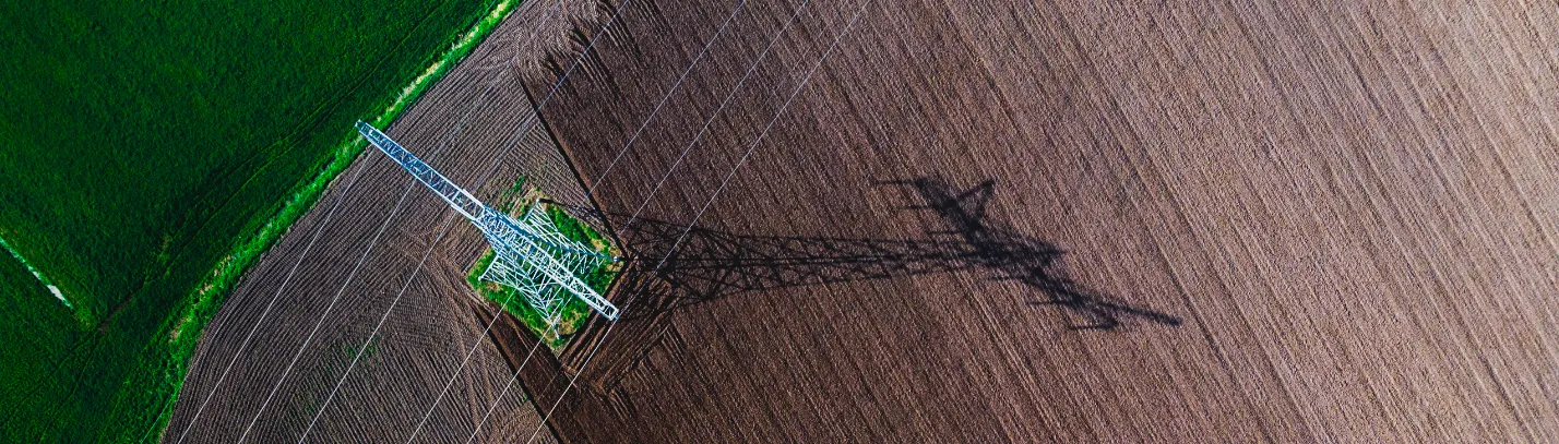 Birds eye view of an electricity plyon in a field